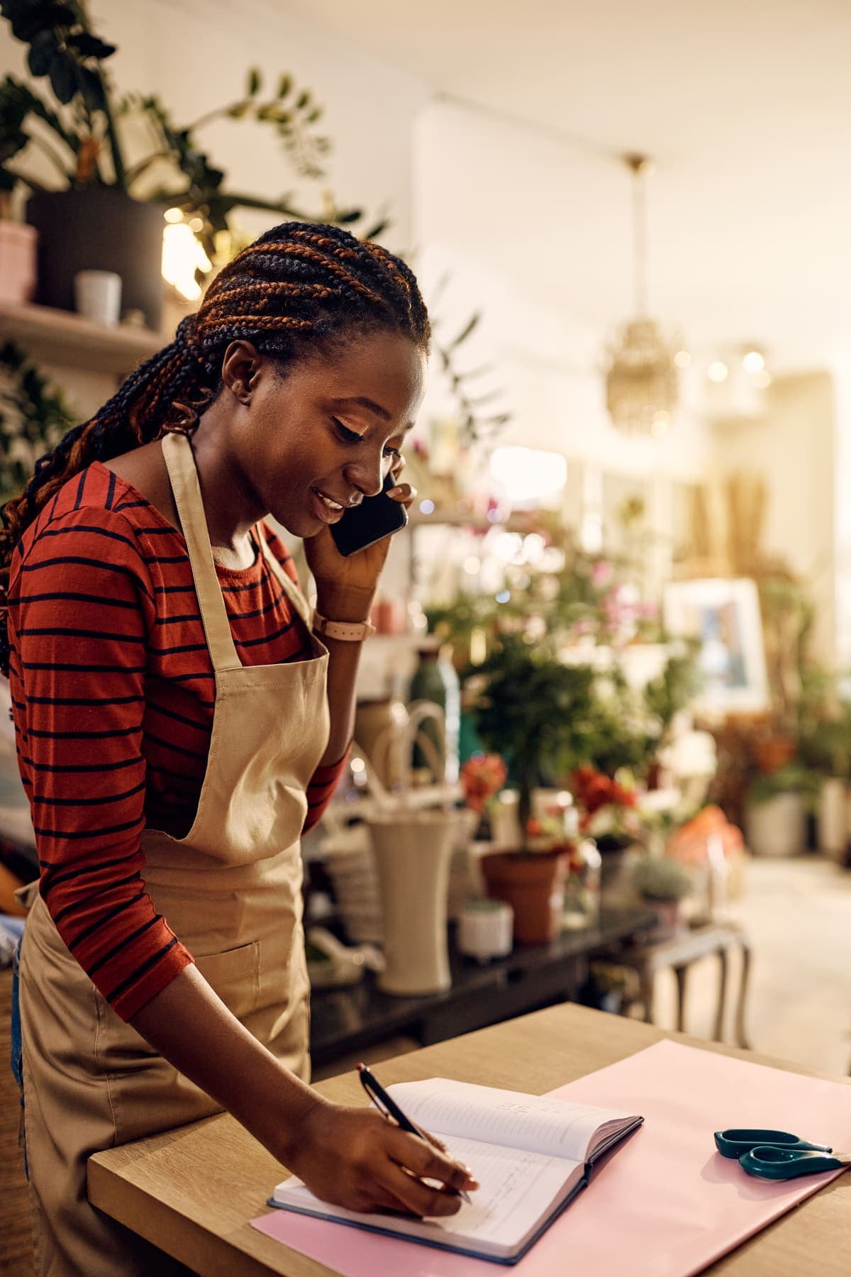 Small business owner taking a customer call in her florist shop.